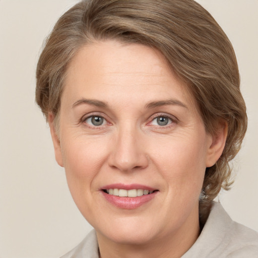 Joyful white adult female with medium  brown hair and grey eyes