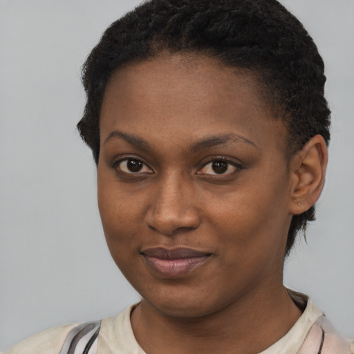 Joyful black young-adult female with short  black hair and brown eyes