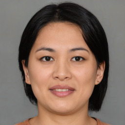 Joyful asian young-adult female with medium  black hair and brown eyes