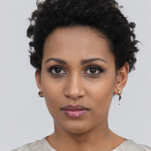 Joyful black young-adult female with short  black hair and brown eyes