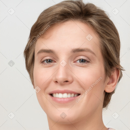 Joyful white young-adult female with medium  brown hair and grey eyes