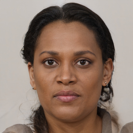 Joyful black adult female with medium  brown hair and brown eyes