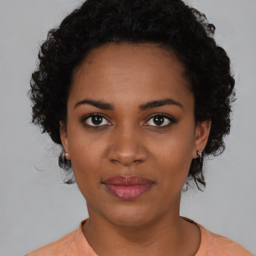 Joyful black young-adult female with short  black hair and brown eyes