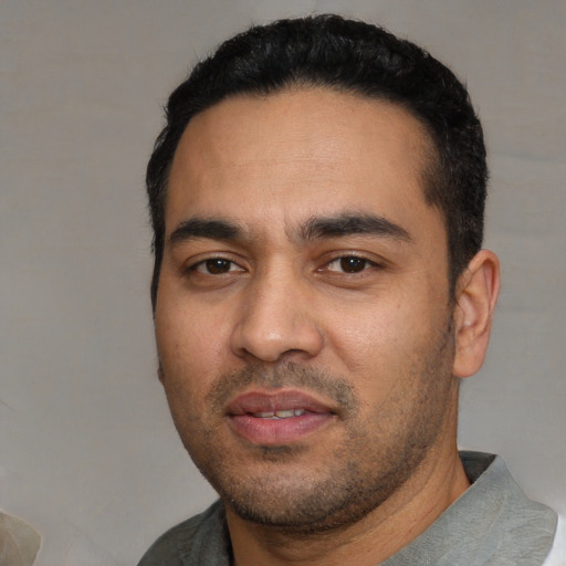 Joyful white young-adult male with short  black hair and brown eyes
