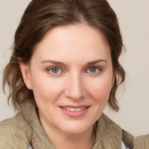 Joyful white young-adult female with medium  brown hair and blue eyes