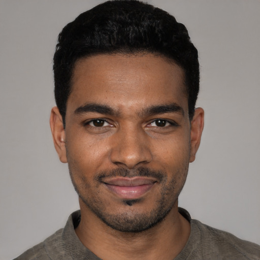 Joyful black young-adult male with short  black hair and brown eyes