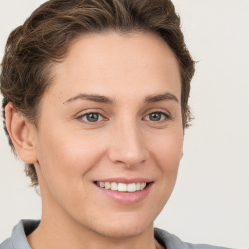 Joyful white young-adult female with short  brown hair and grey eyes