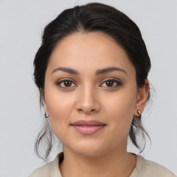 Joyful latino young-adult female with medium  brown hair and brown eyes