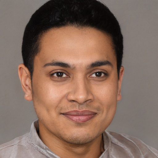 Joyful latino young-adult male with short  brown hair and brown eyes