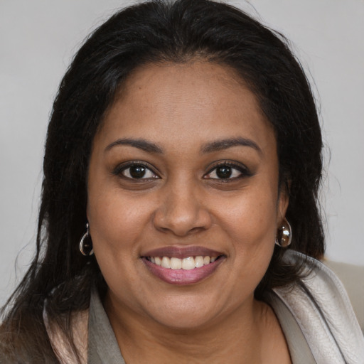 Joyful black young-adult female with long  brown hair and brown eyes