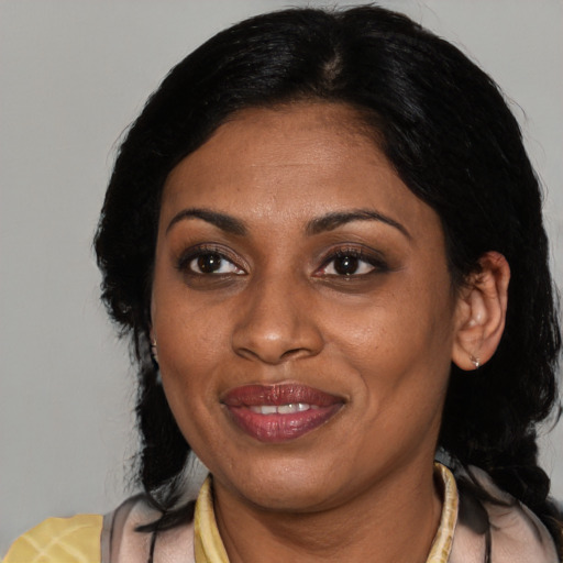 Joyful latino adult female with medium  black hair and brown eyes