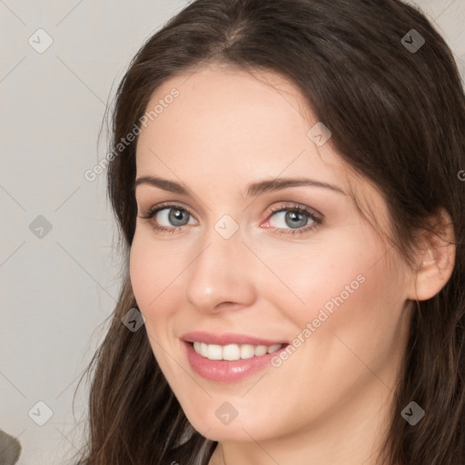 Joyful white young-adult female with long  brown hair and grey eyes