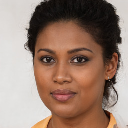 Joyful black young-adult female with long  brown hair and brown eyes