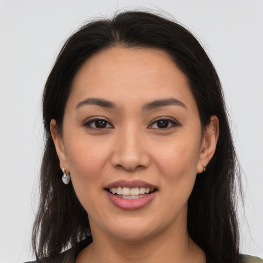 Joyful latino young-adult female with long  brown hair and brown eyes