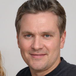 Joyful white adult male with short  brown hair and brown eyes