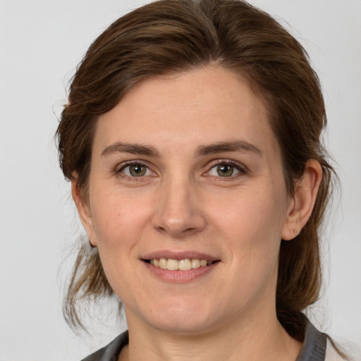 Joyful white young-adult female with medium  brown hair and grey eyes