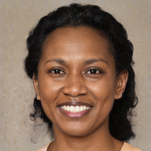Joyful black adult female with medium  black hair and brown eyes
