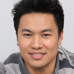 Joyful asian young-adult male with short  brown hair and brown eyes