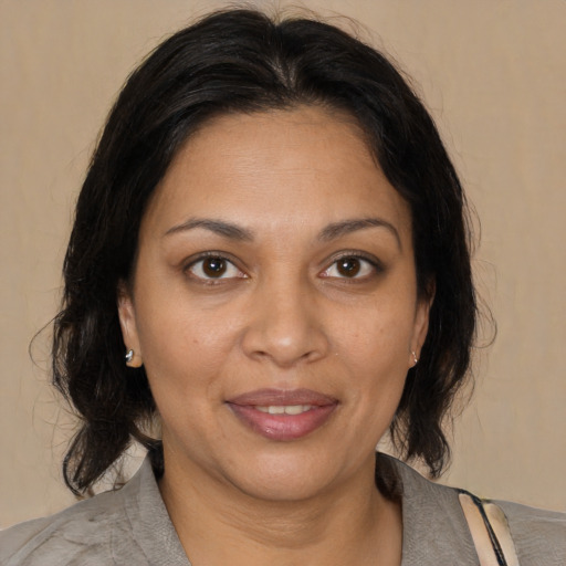 Joyful black adult female with medium  brown hair and brown eyes