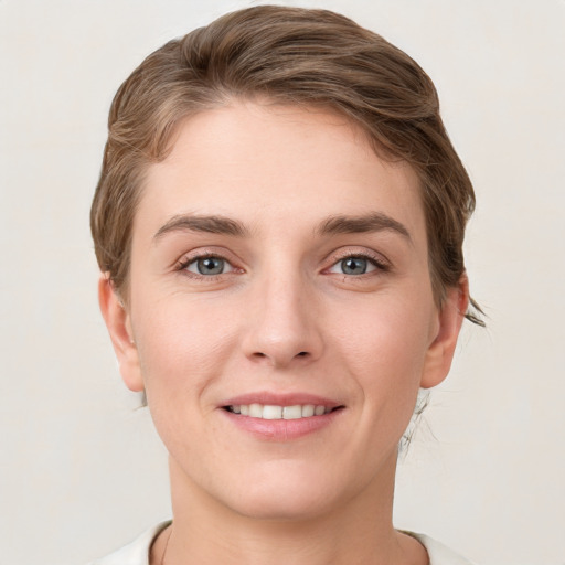 Joyful white young-adult female with short  brown hair and grey eyes