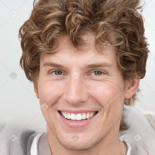 Joyful white young-adult male with short  brown hair and blue eyes