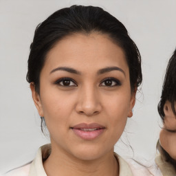 Joyful latino young-adult female with medium  brown hair and brown eyes