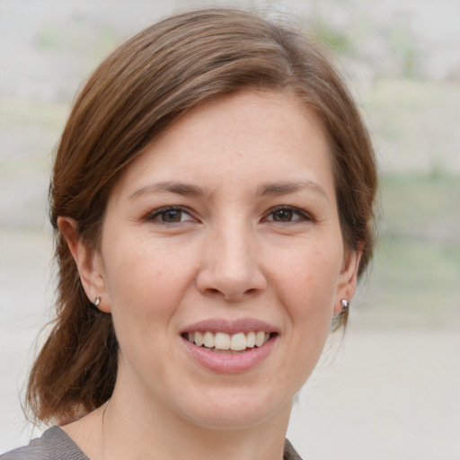 Joyful white young-adult female with medium  brown hair and grey eyes