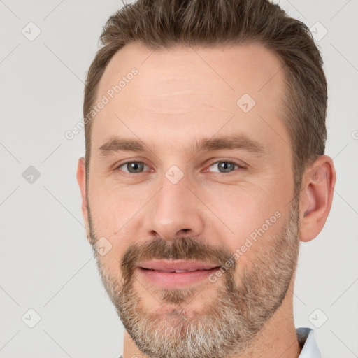 Joyful white adult male with short  brown hair and brown eyes