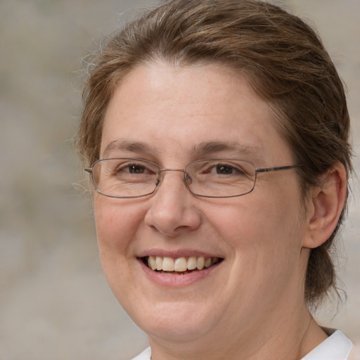 Joyful white adult female with medium  brown hair and green eyes