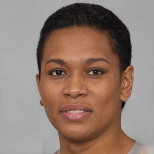 Joyful black young-adult female with short  black hair and brown eyes