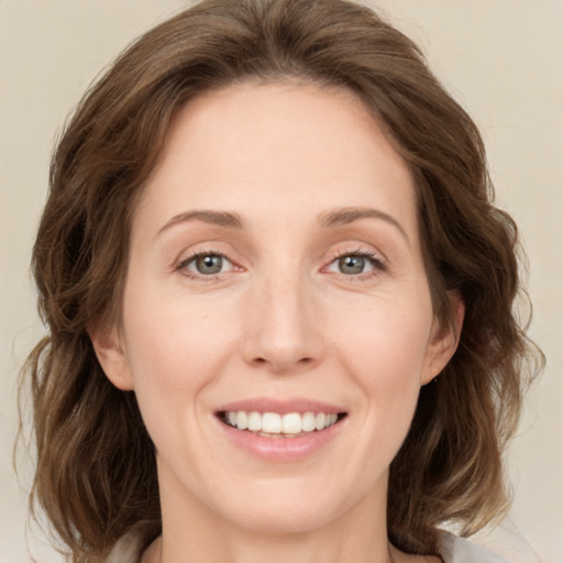 Joyful white adult female with medium  brown hair and green eyes