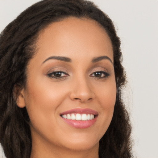 Joyful latino young-adult female with long  brown hair and brown eyes