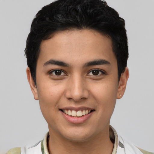 Joyful latino young-adult male with short  brown hair and brown eyes