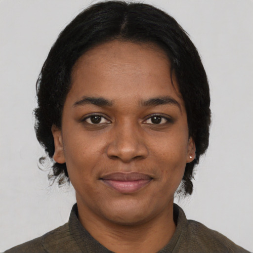 Joyful black young-adult female with short  black hair and brown eyes