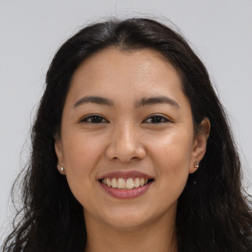 Joyful latino young-adult female with long  brown hair and brown eyes