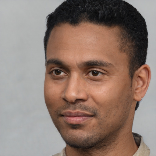 Joyful latino young-adult male with short  black hair and brown eyes