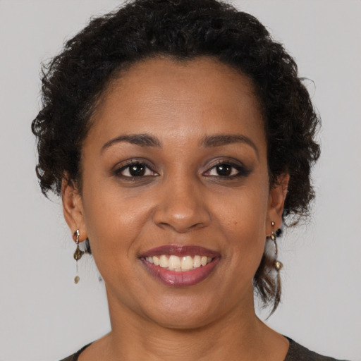 Joyful black young-adult female with short  brown hair and brown eyes