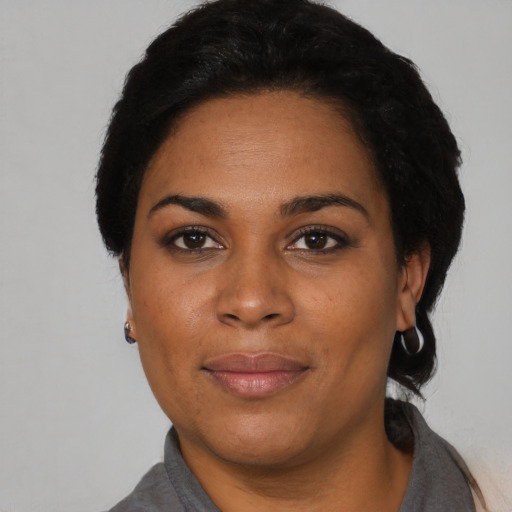 Joyful black young-adult female with short  black hair and brown eyes