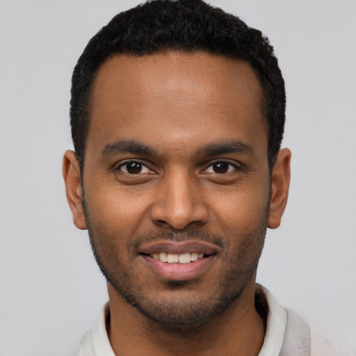 Joyful black young-adult male with short  black hair and brown eyes
