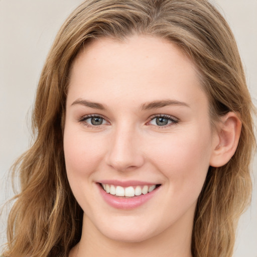 Joyful white young-adult female with long  brown hair and blue eyes