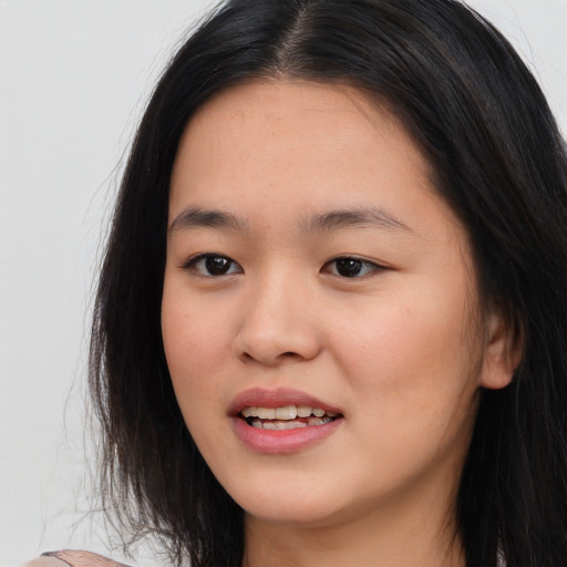 Joyful asian young-adult female with long  brown hair and brown eyes