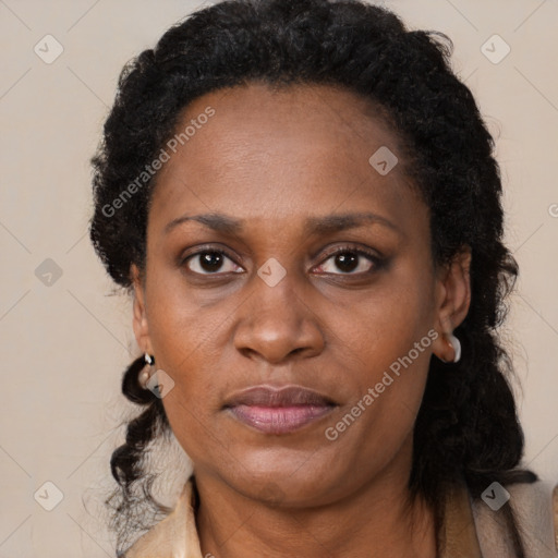 Joyful black adult female with long  black hair and brown eyes