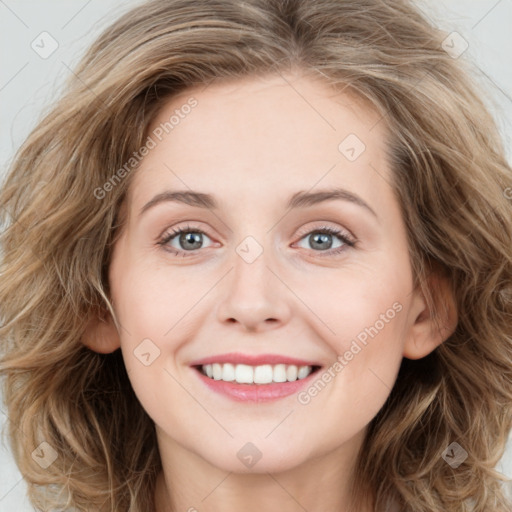 Joyful white young-adult female with long  brown hair and green eyes