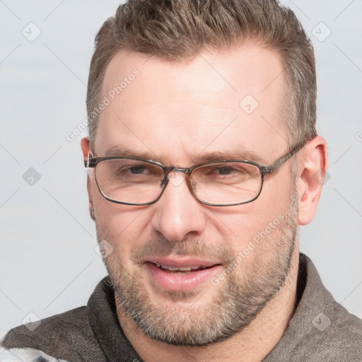 Joyful white adult male with short  brown hair and blue eyes