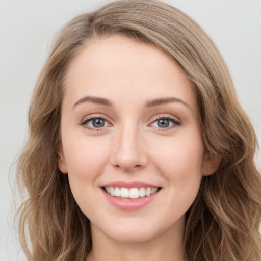 Joyful white young-adult female with long  brown hair and blue eyes