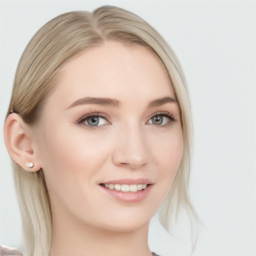 Joyful white young-adult female with long  blond hair and blue eyes