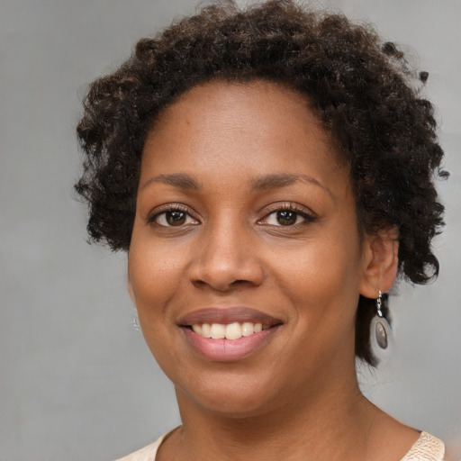 Joyful black young-adult female with short  brown hair and brown eyes
