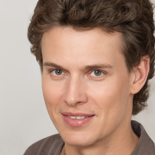 Joyful white young-adult male with medium  brown hair and brown eyes