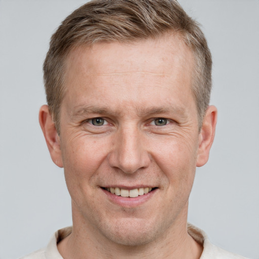 Joyful white adult male with short  brown hair and grey eyes