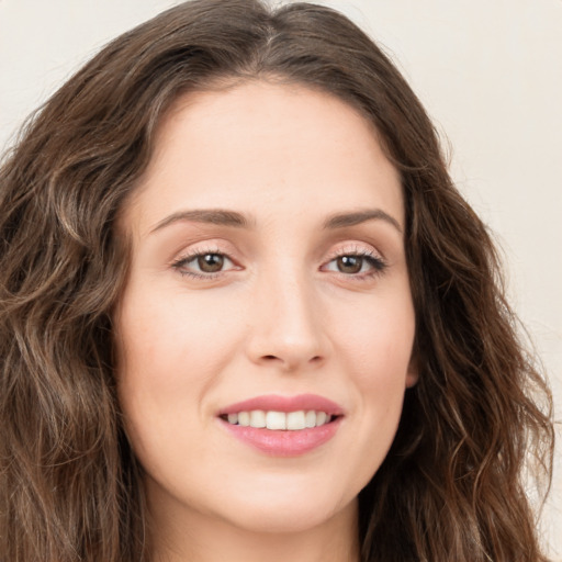 Joyful white young-adult female with long  brown hair and green eyes